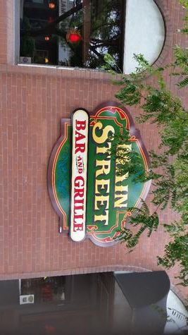 Sign for The Main Street Bar & Grille on a brick building.