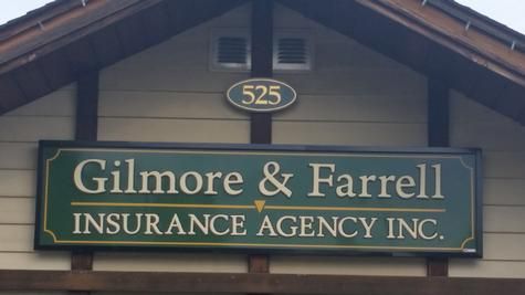 Sign for Gilmore & Farrell Insurance Agency Inc. at 525, with green and gold text on a beige building.