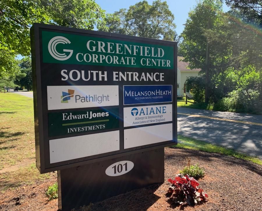Sign for Greenfield Corporate Center South Entrance, with logos of businesses and address 101.