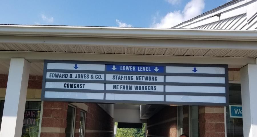 Sign with business names and directions to lower level