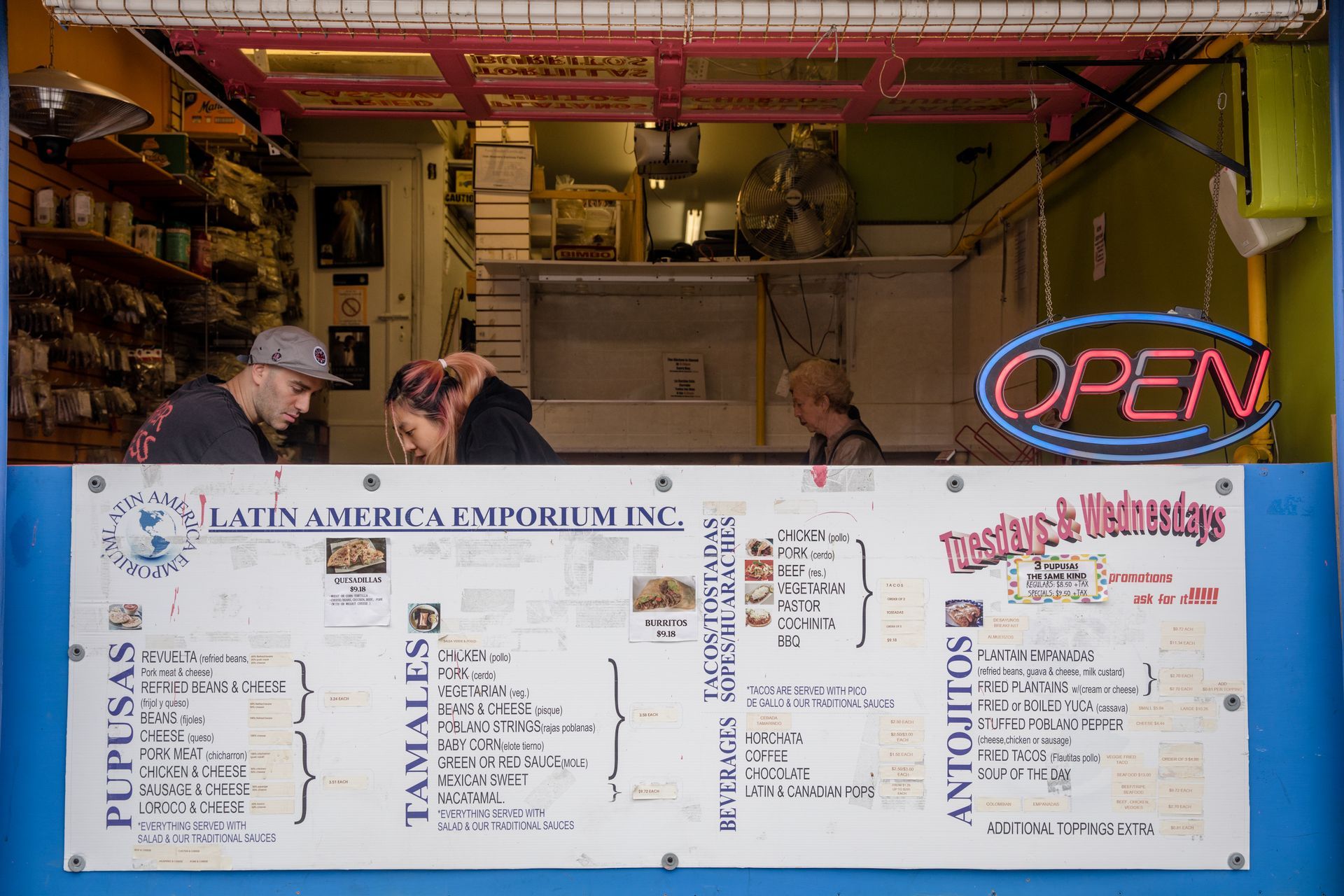 Latin America Emporium food stand with menu and staff, blue and pink, 