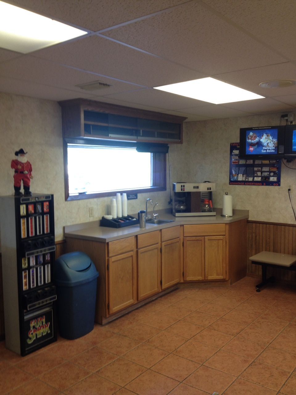 A kitchen with wooden cabinets and a trash can