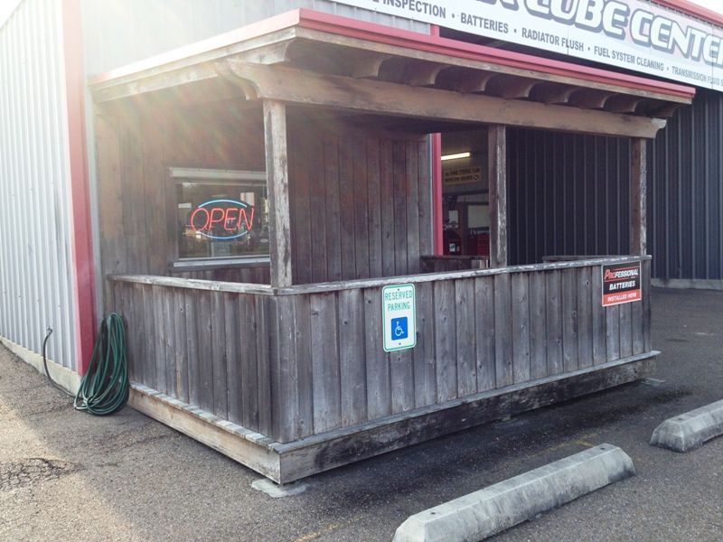 A wooden building with a sign that says open on it