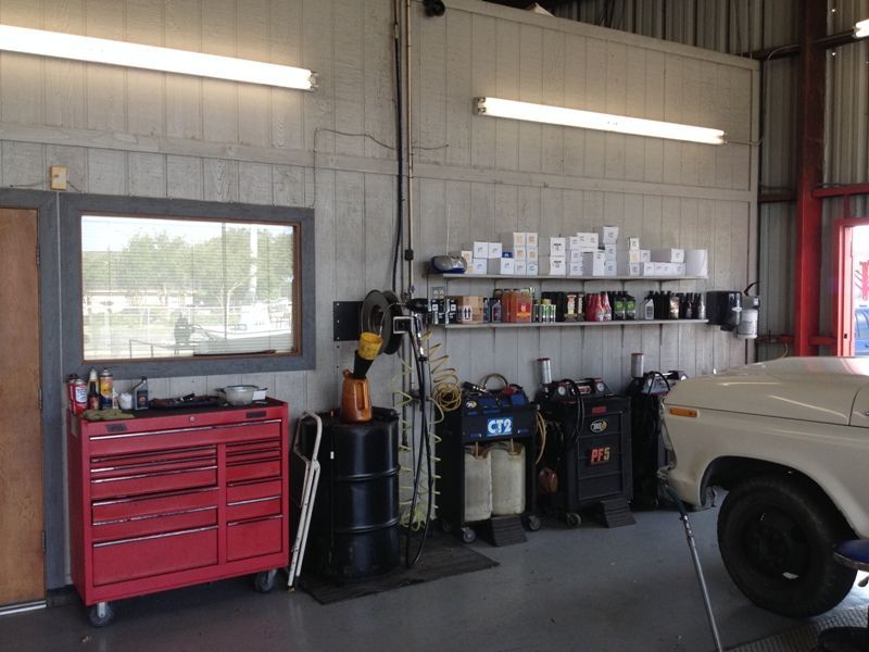 A car is parked in a garage next to a red toolbox
