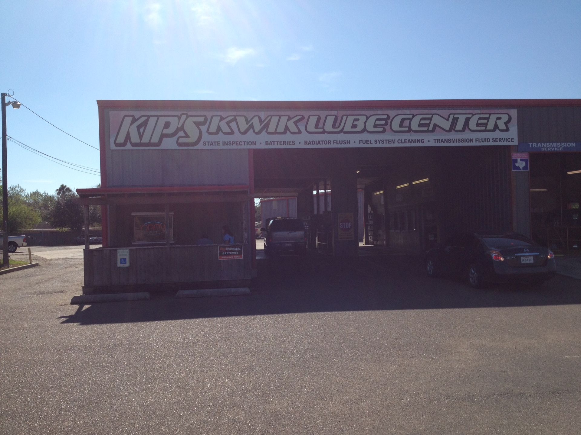 A car is parked in front of a shop called kips kwik lube center