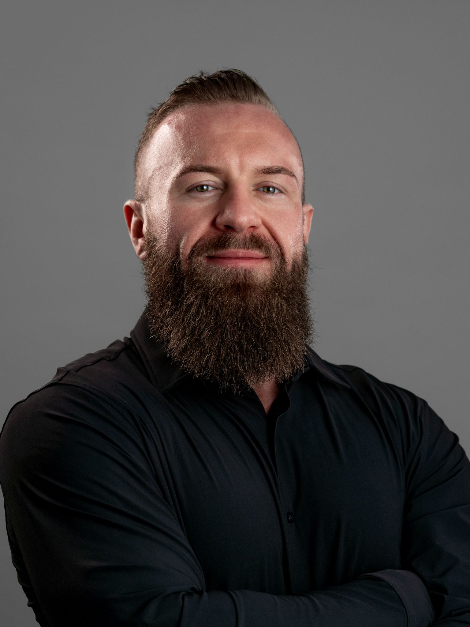 A man with a beard is wearing a black shirt.