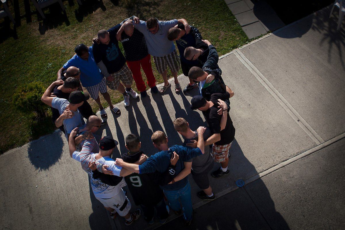 A group of people are standing in a circle and one of them has the number 9 on his back