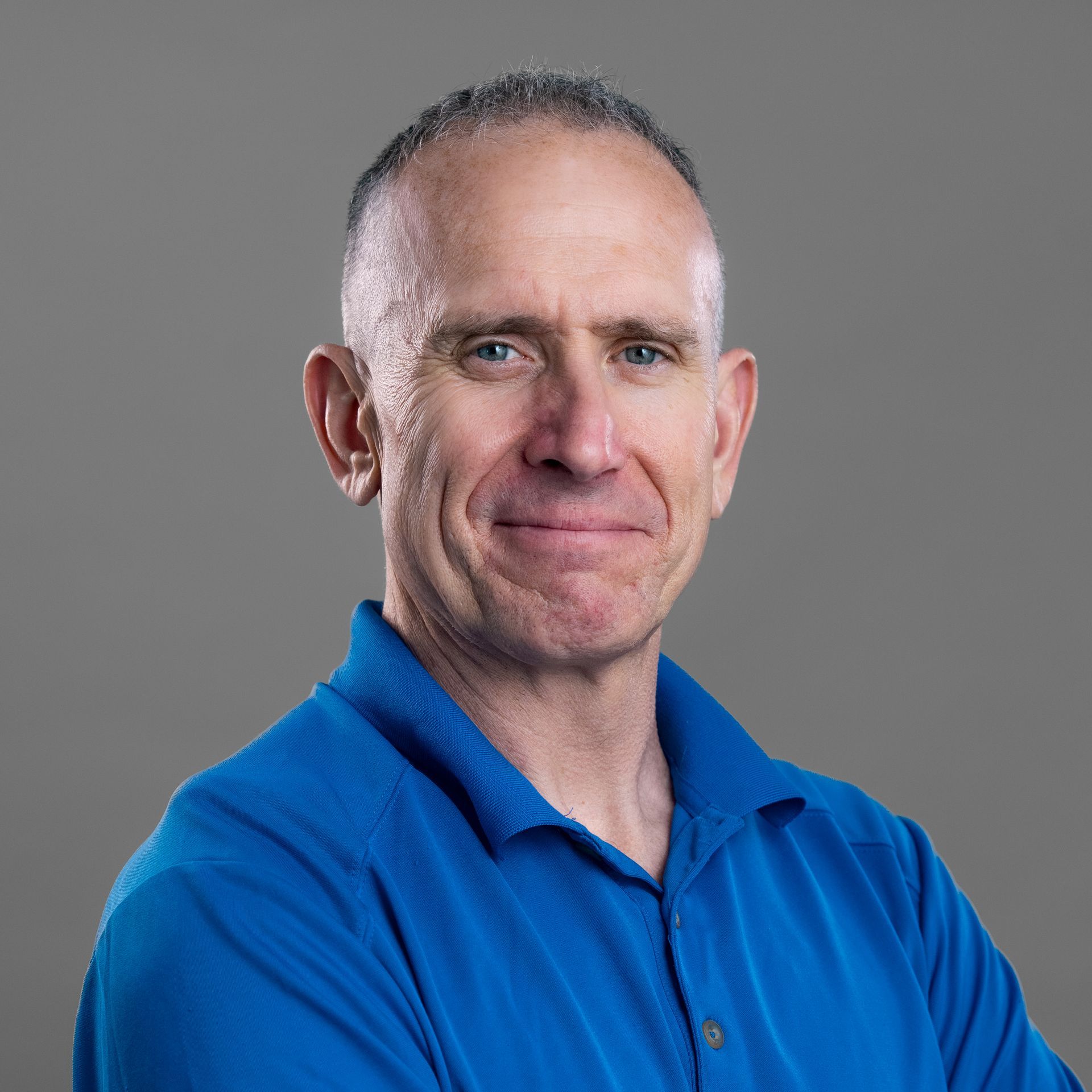 A man in a blue shirt is smiling for the camera.