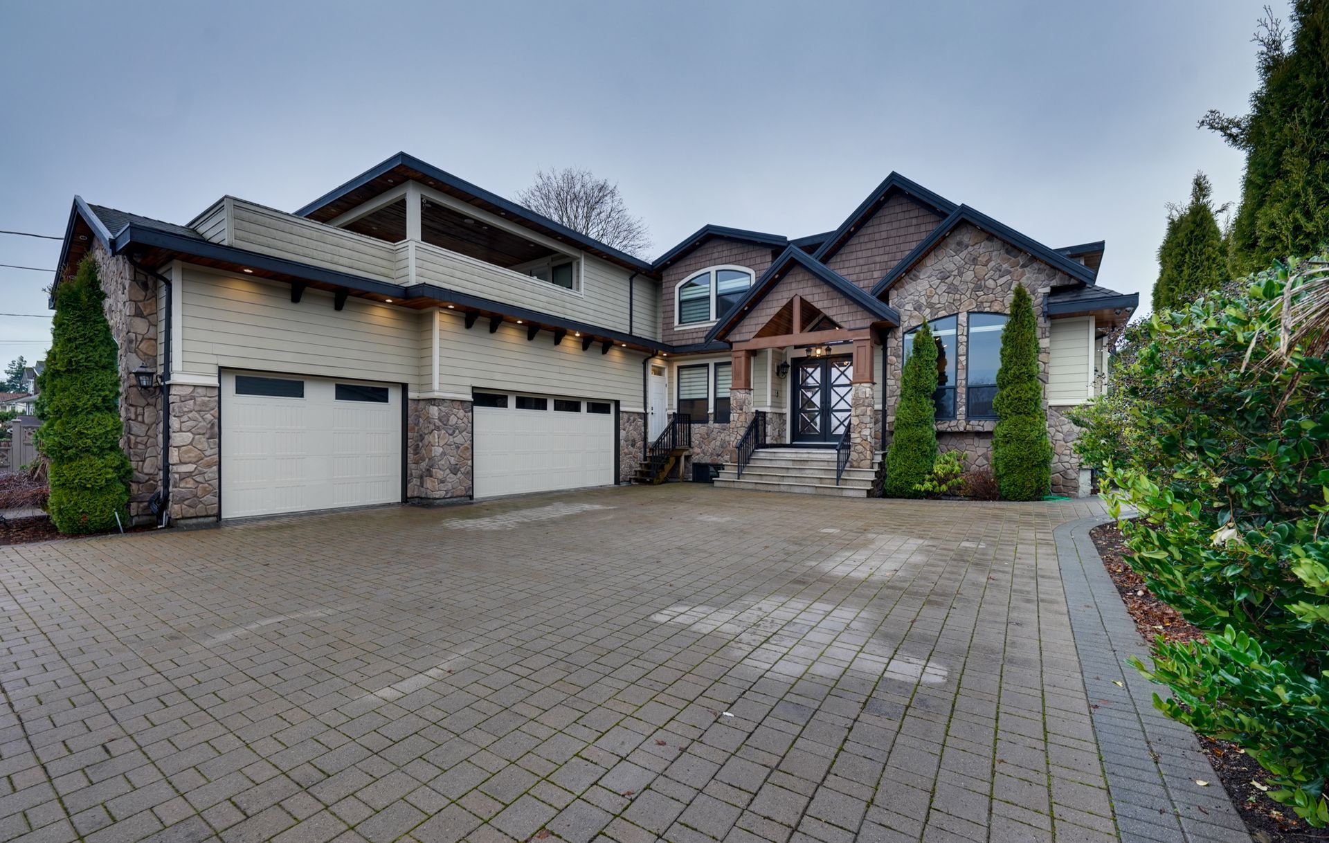 A large house with a brick driveway in front of it