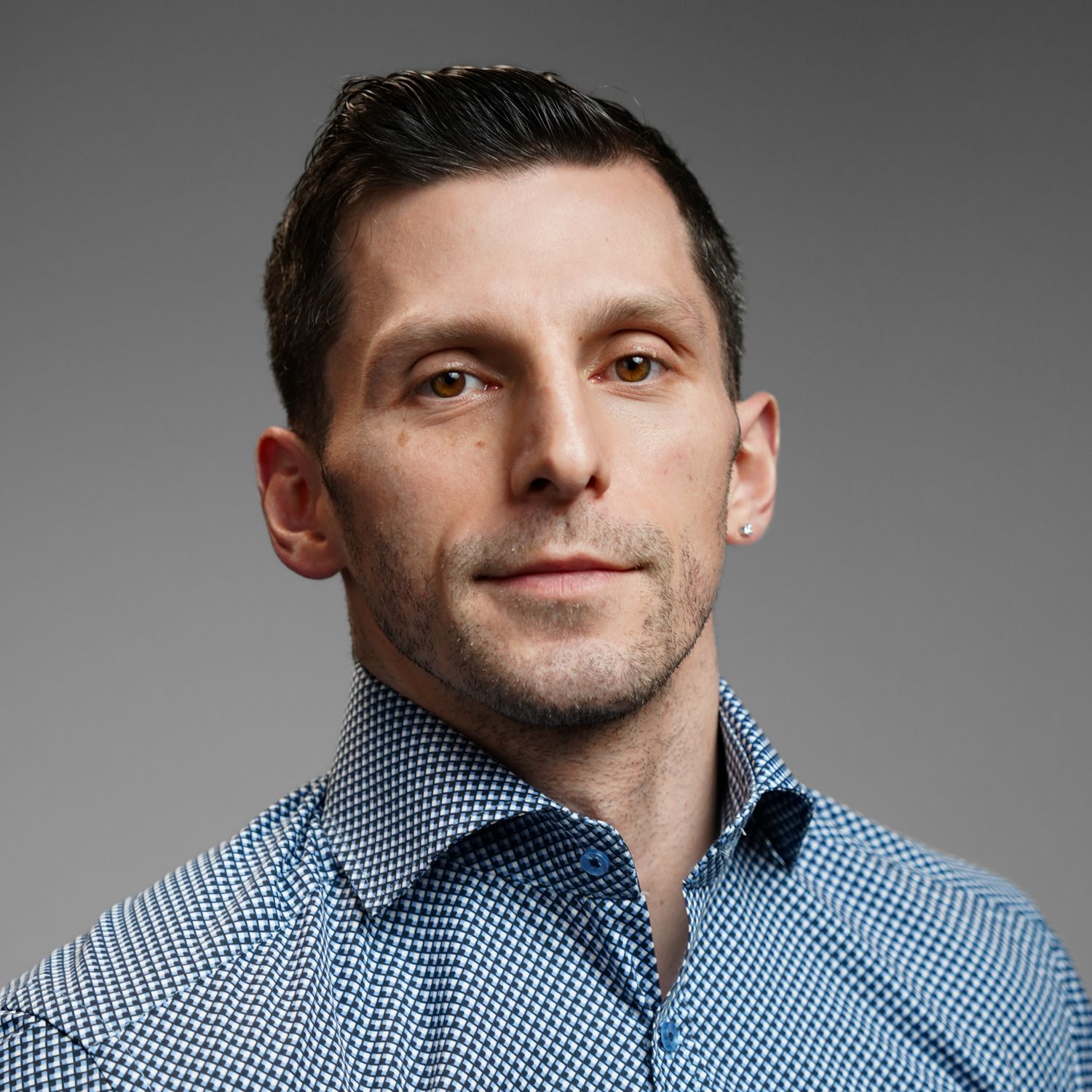 A man in a blue shirt is smiling for the camera.