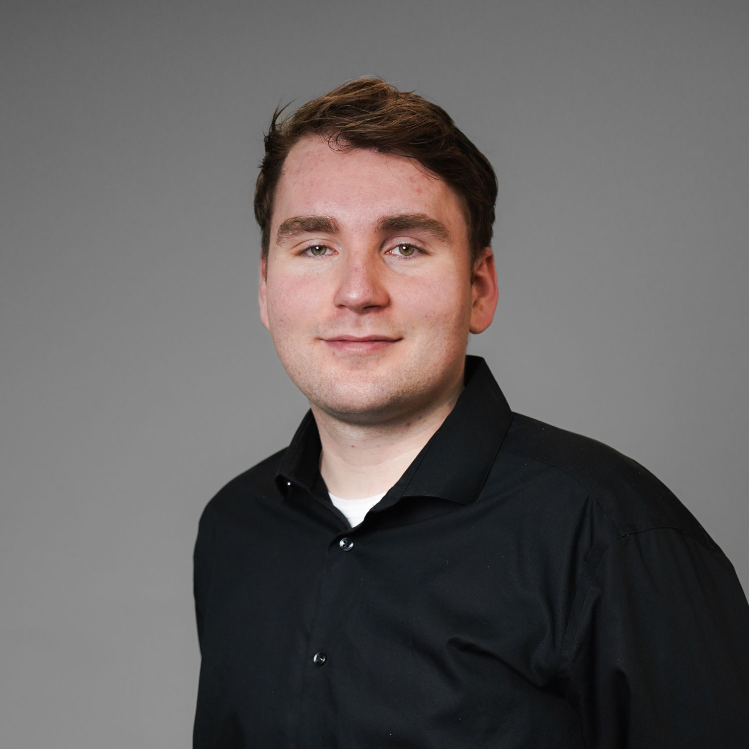 A man in a black shirt is smiling for the camera