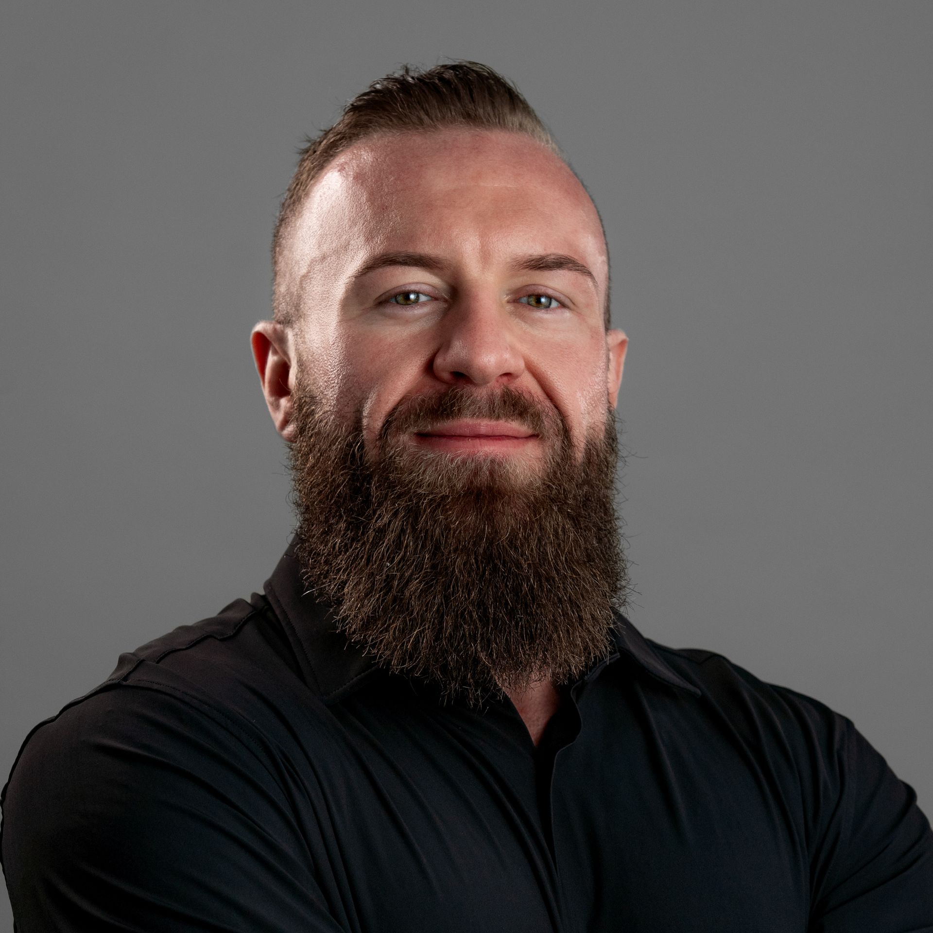 A man with a beard is wearing a black shirt.