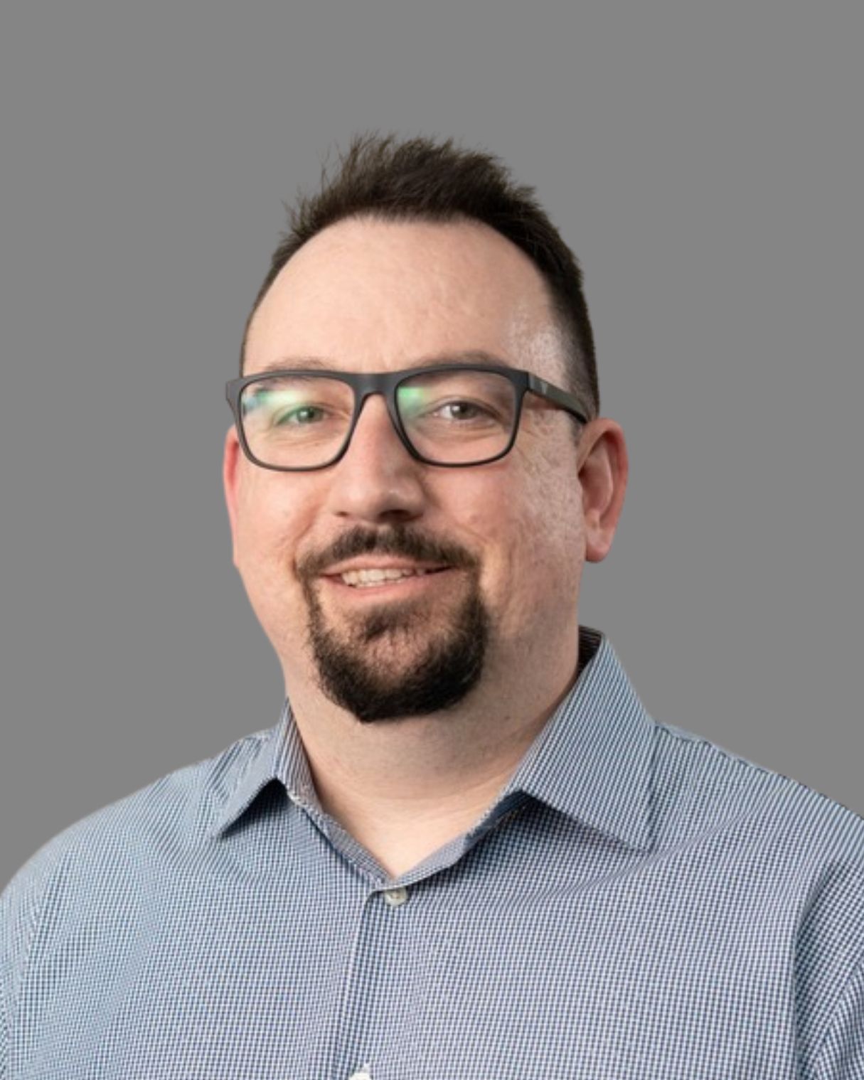 A man with a beard wearing glasses and a white shirt