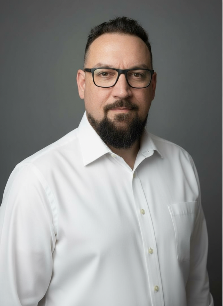 A man with a beard wearing glasses and a white shirt