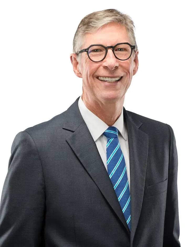 A man in a suit and tie is smiling for the camera.