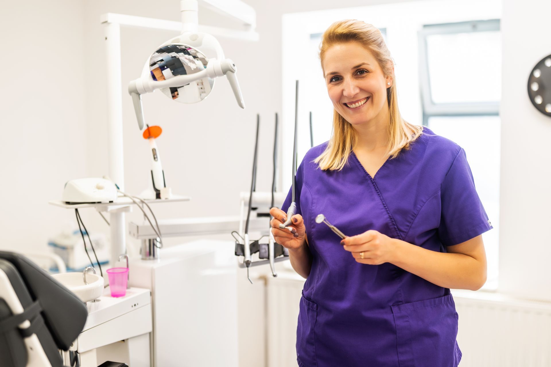 Dental tech in purple scrubs smiles, in Villa Rica, GA 30180.