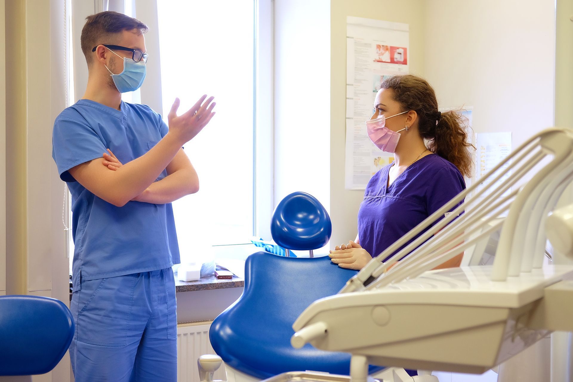 Two people in scrubs and masks talking in a dentist's office in Villa Rica, GA 30180