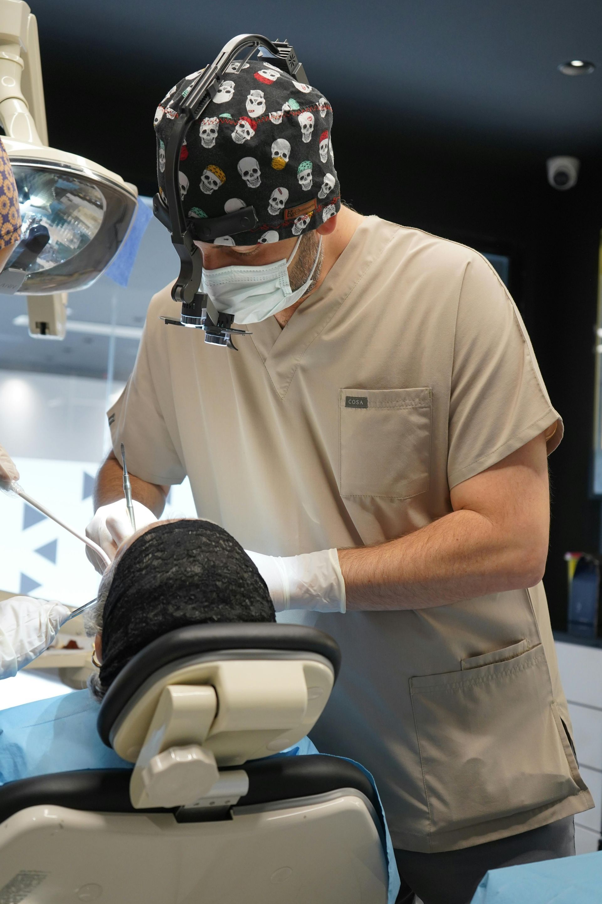 A dentist is working on a patient in a dental chair.