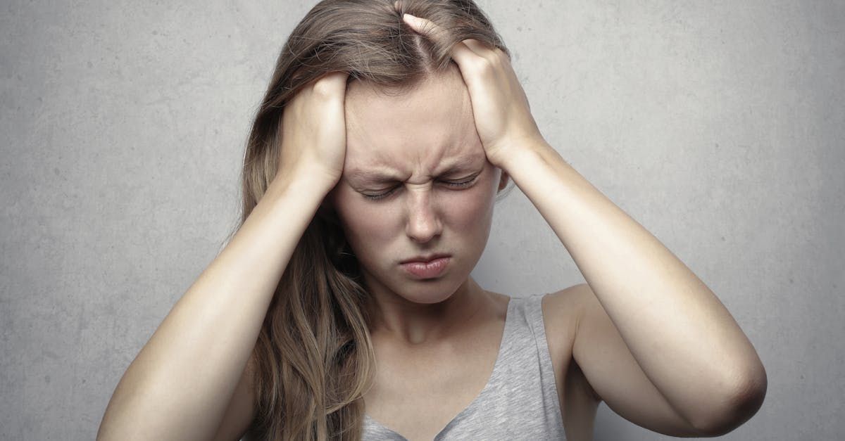 A woman is holding her head in pain.