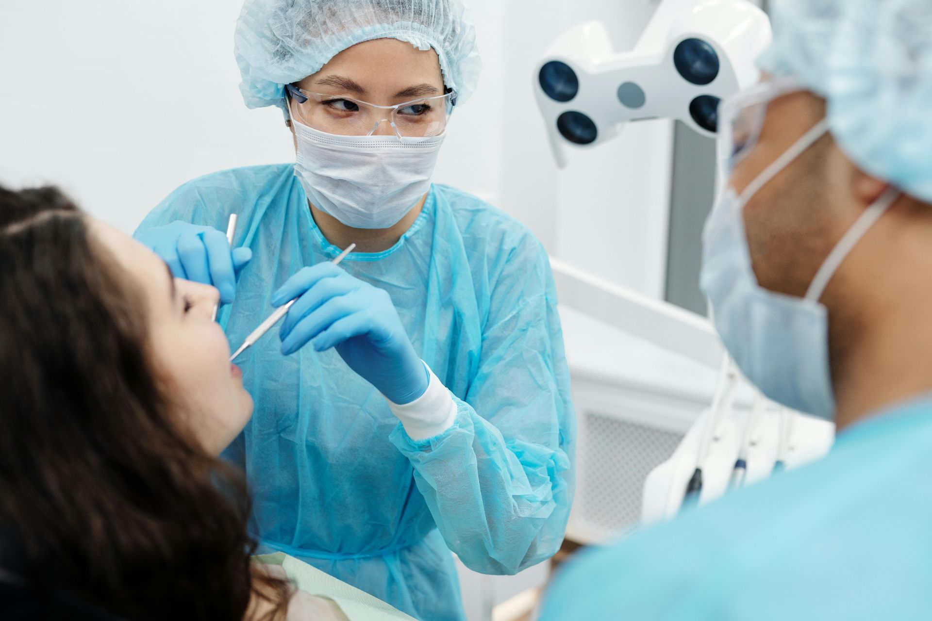 A dentist is examining a patient 's teeth in a dental office.