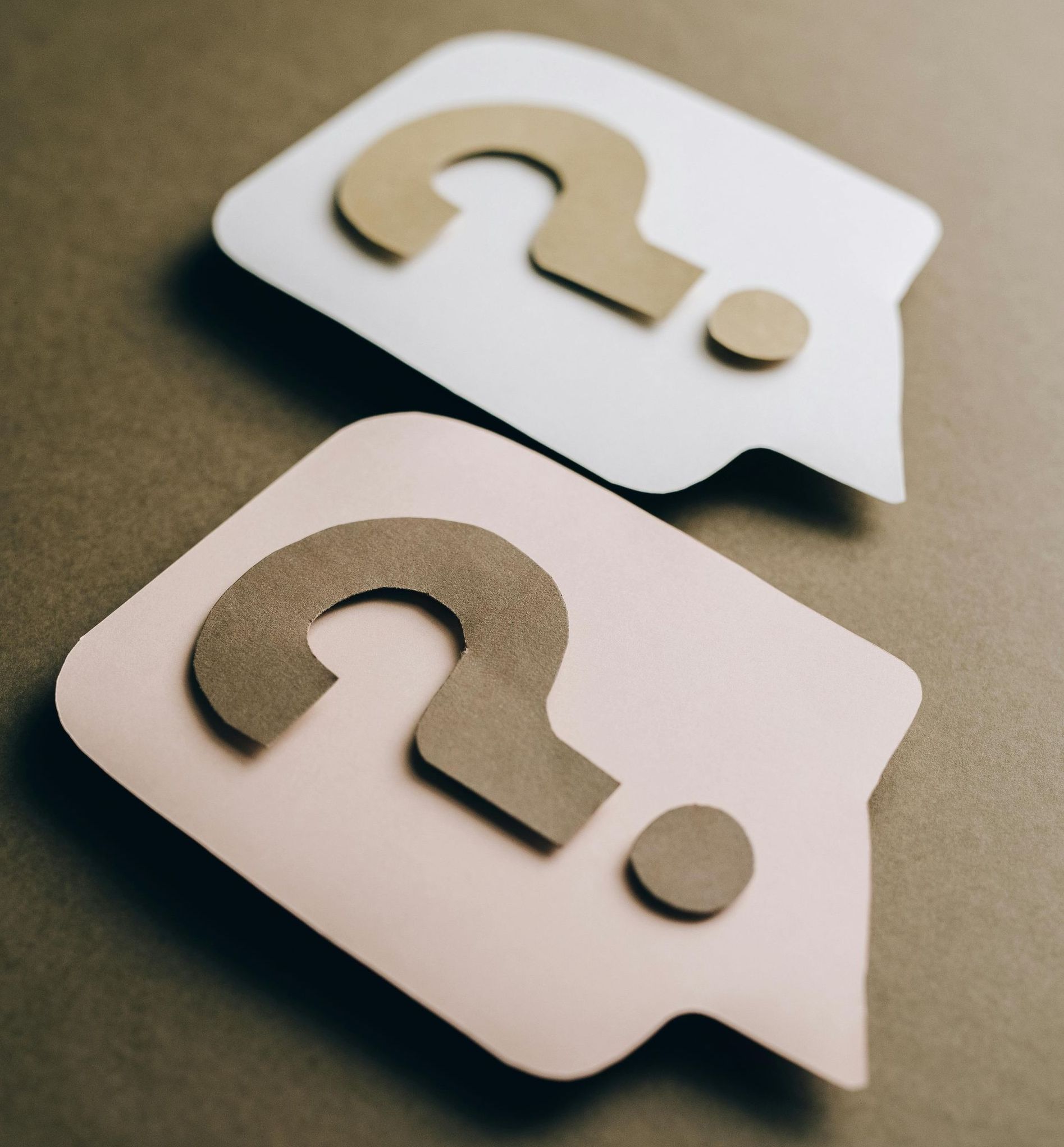 Two speech bubbles with question marks on them
