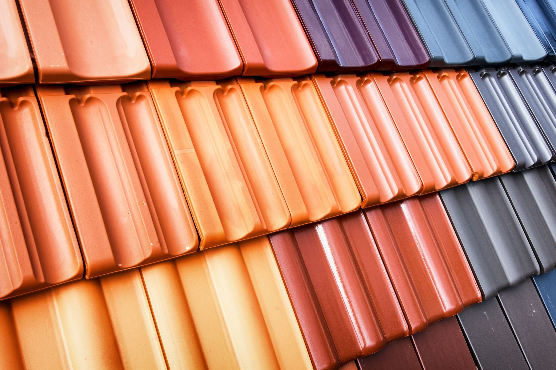 Rows of colorful roof tiles: orange, red, and blue shades.