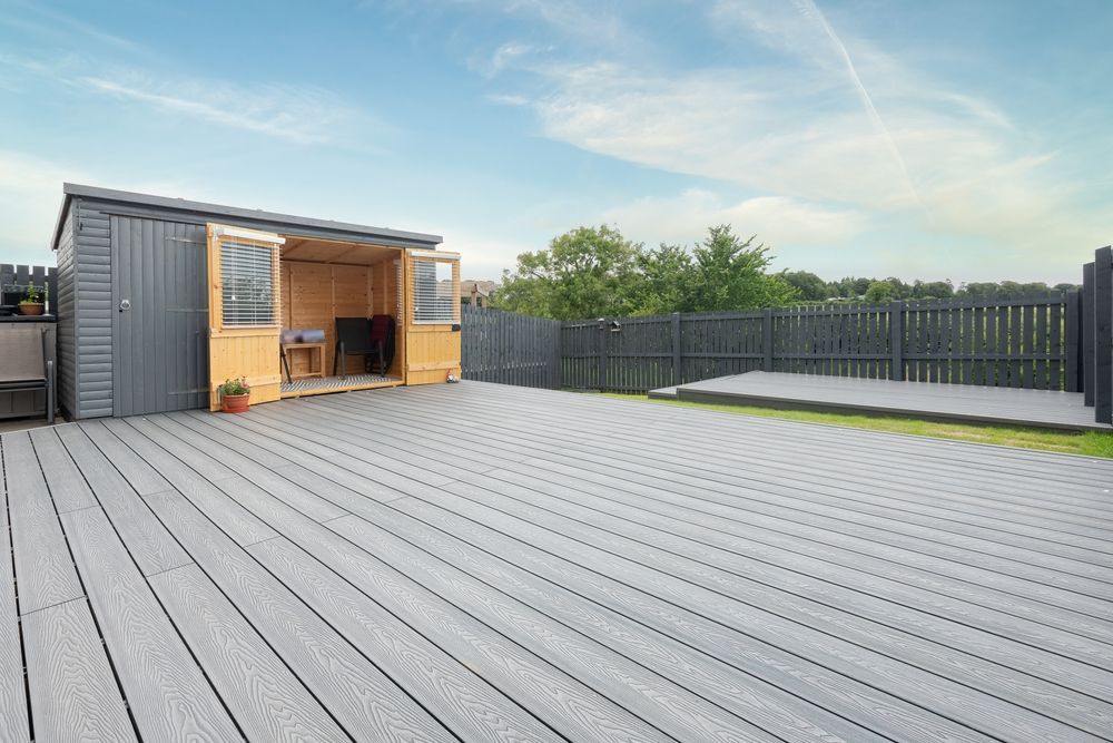 A wooden shed is sitting on top of a wooden deck.