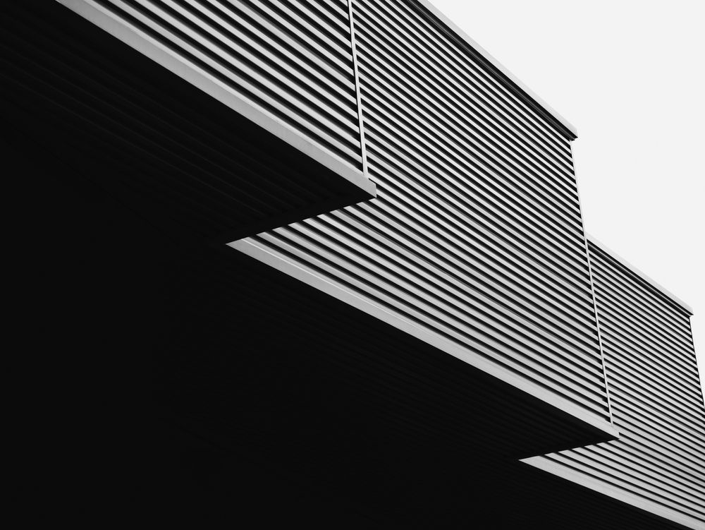 A black and white photo of a building with blinds on it