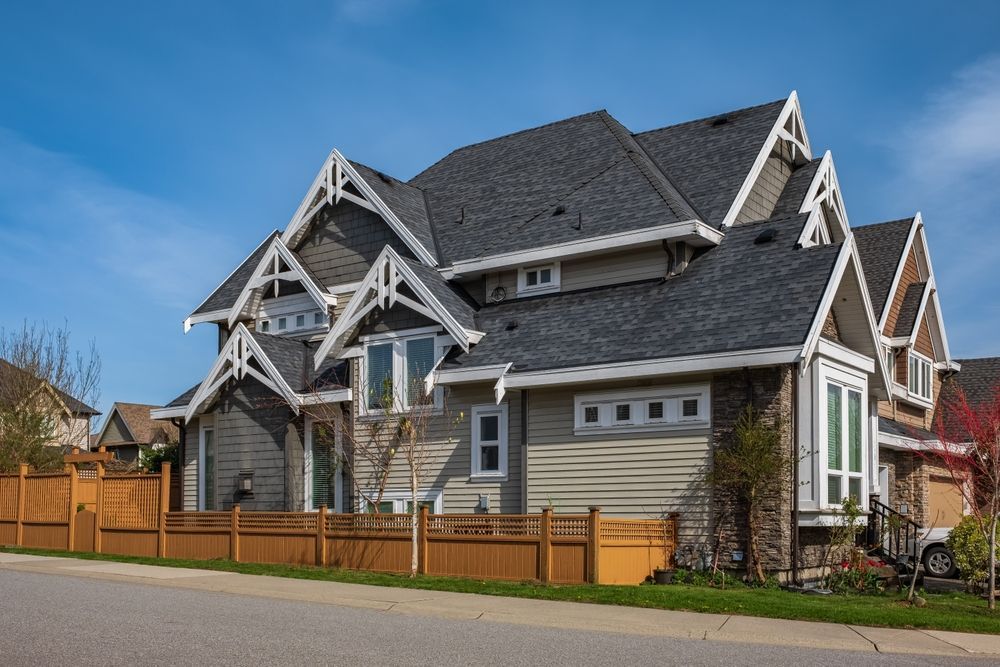 A large house with a wooden fence in front of it.