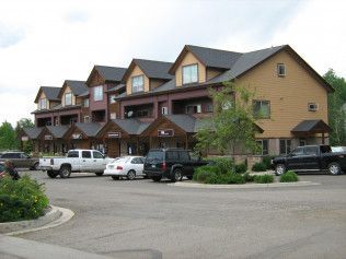 A row of houses with cars parked in front of them