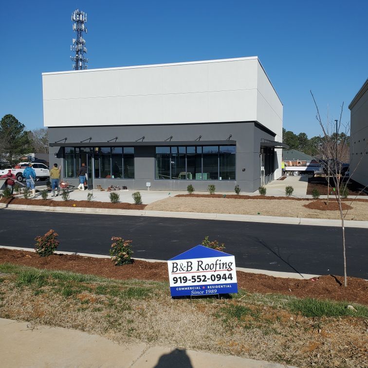 A b & b roofing sign in front of a building