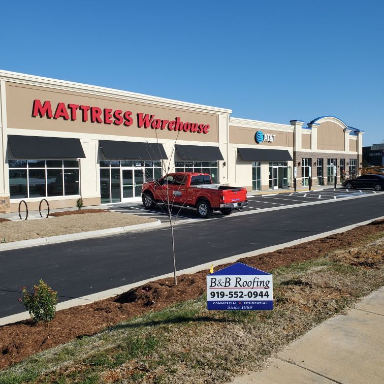 A red truck is parked in front of a mattress warehouse