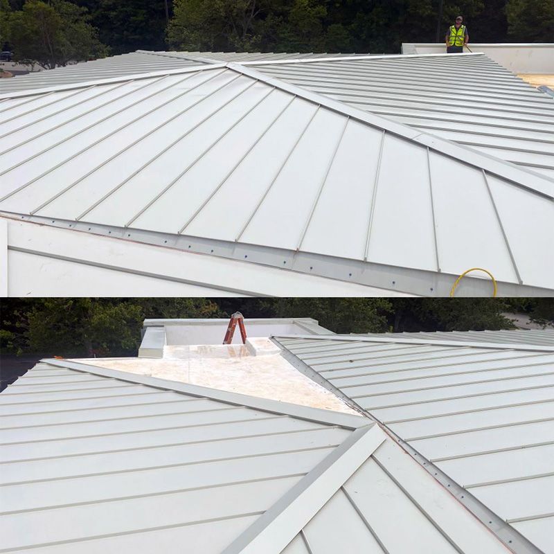 A man in a yellow vest is standing on top of a white roof