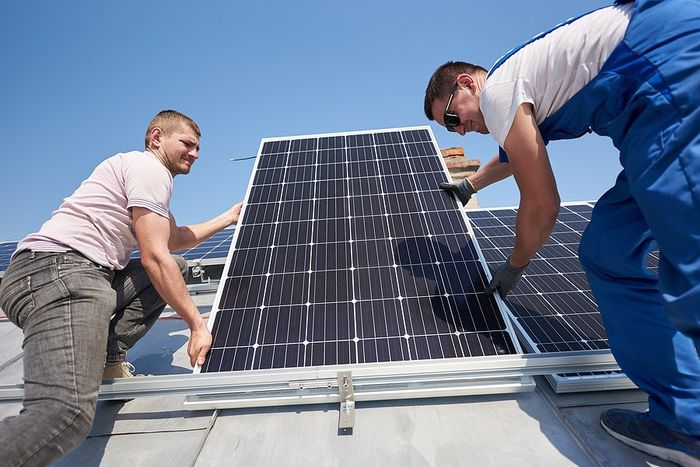 two people holding the solar panel