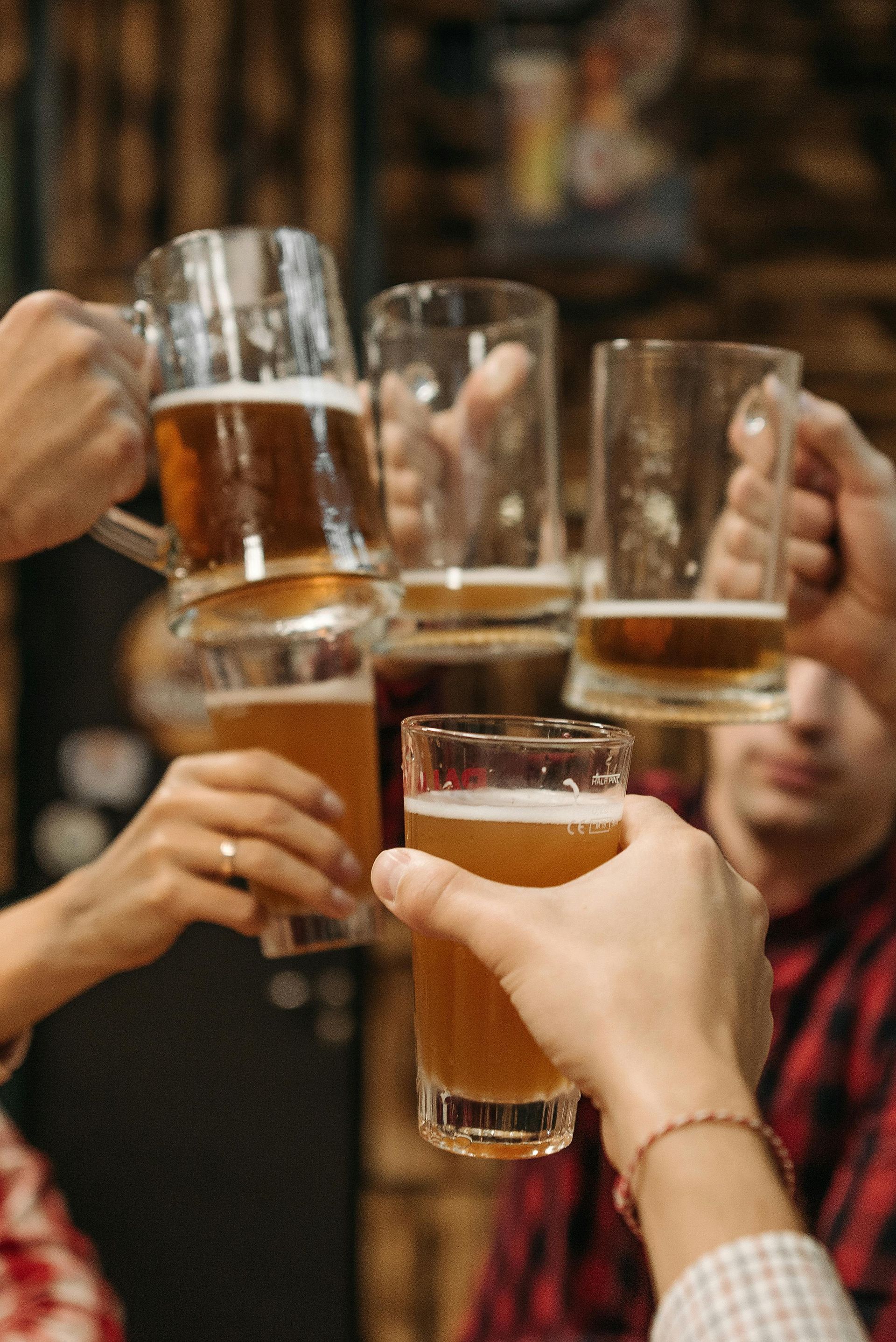 A group of people are toasting with beer mugs.