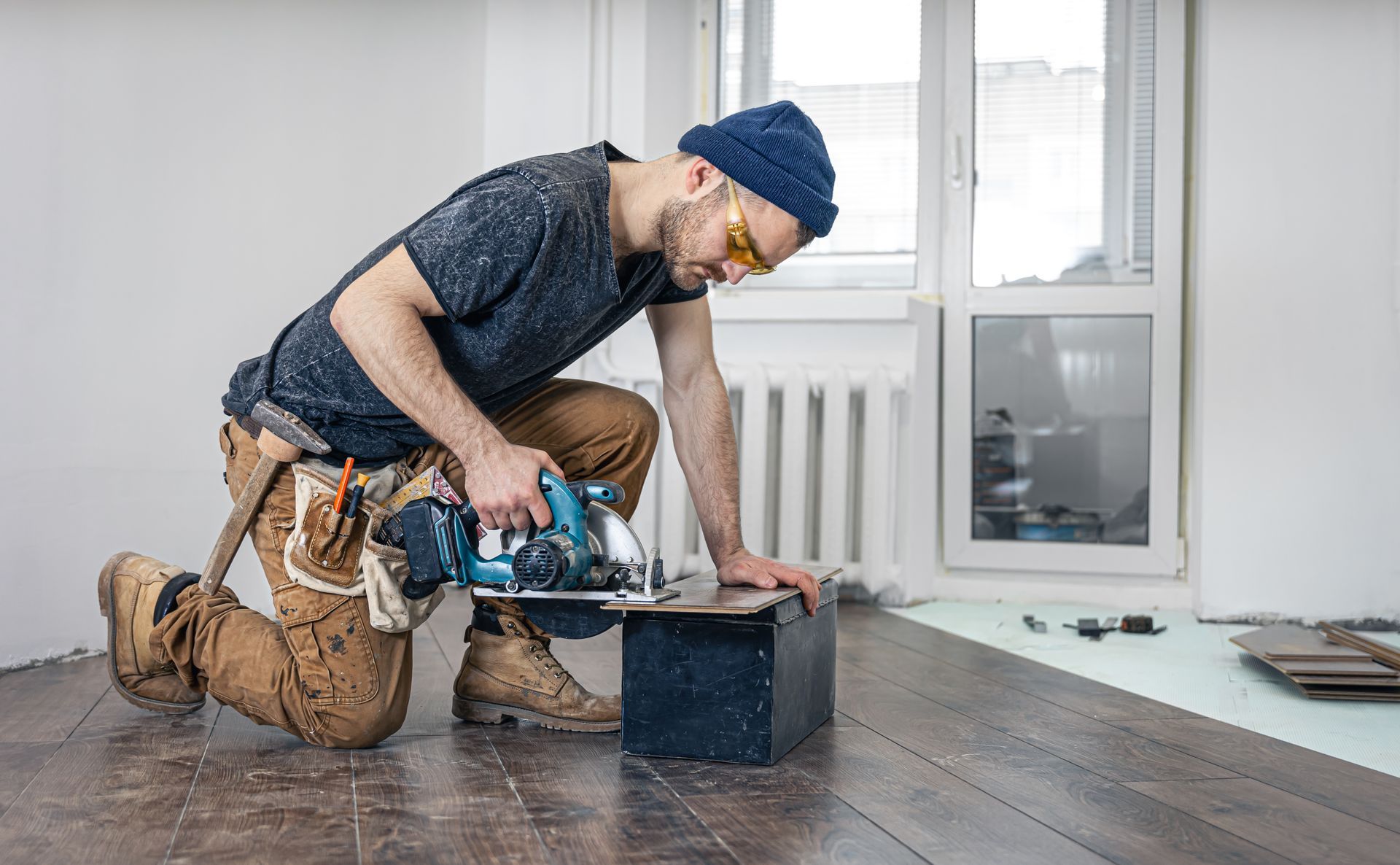 Homme travaillant dans le bâtiment en train d'utiliser une scie circulaire pour couper des planches de bois