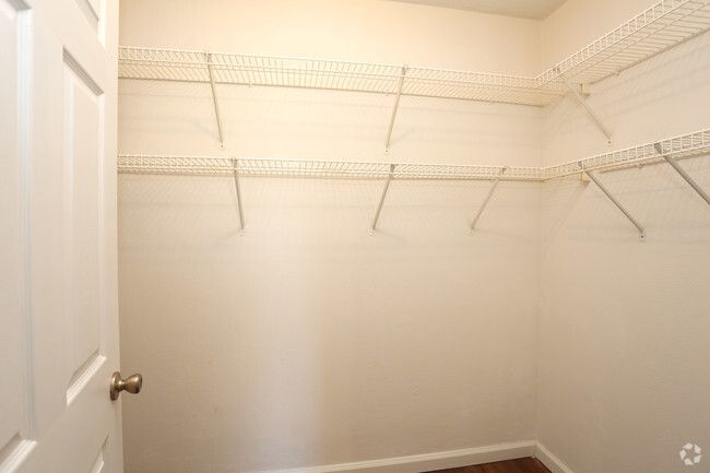 An empty walk in closet with shelves and a door.