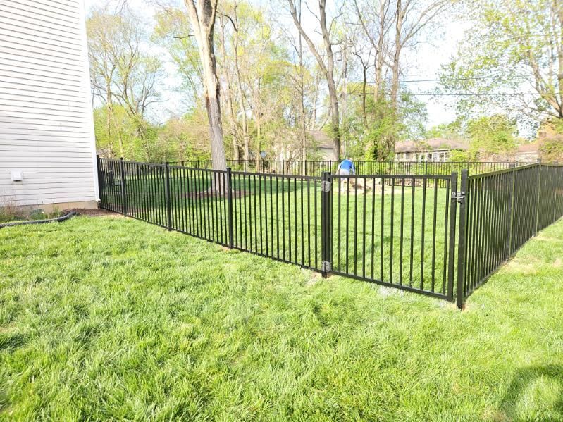 A wooden gate is sitting next to a wooden fence.