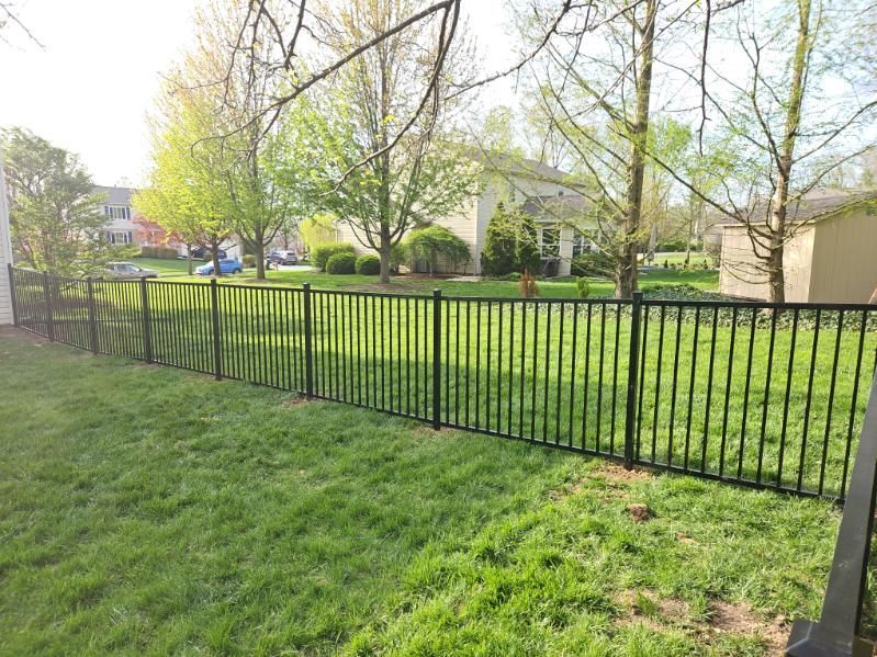 A wooden gate is sitting next to a wooden fence.