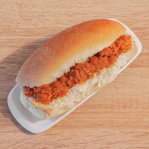 Een heleboel eten ligt op een wit bord op een houten tafel.