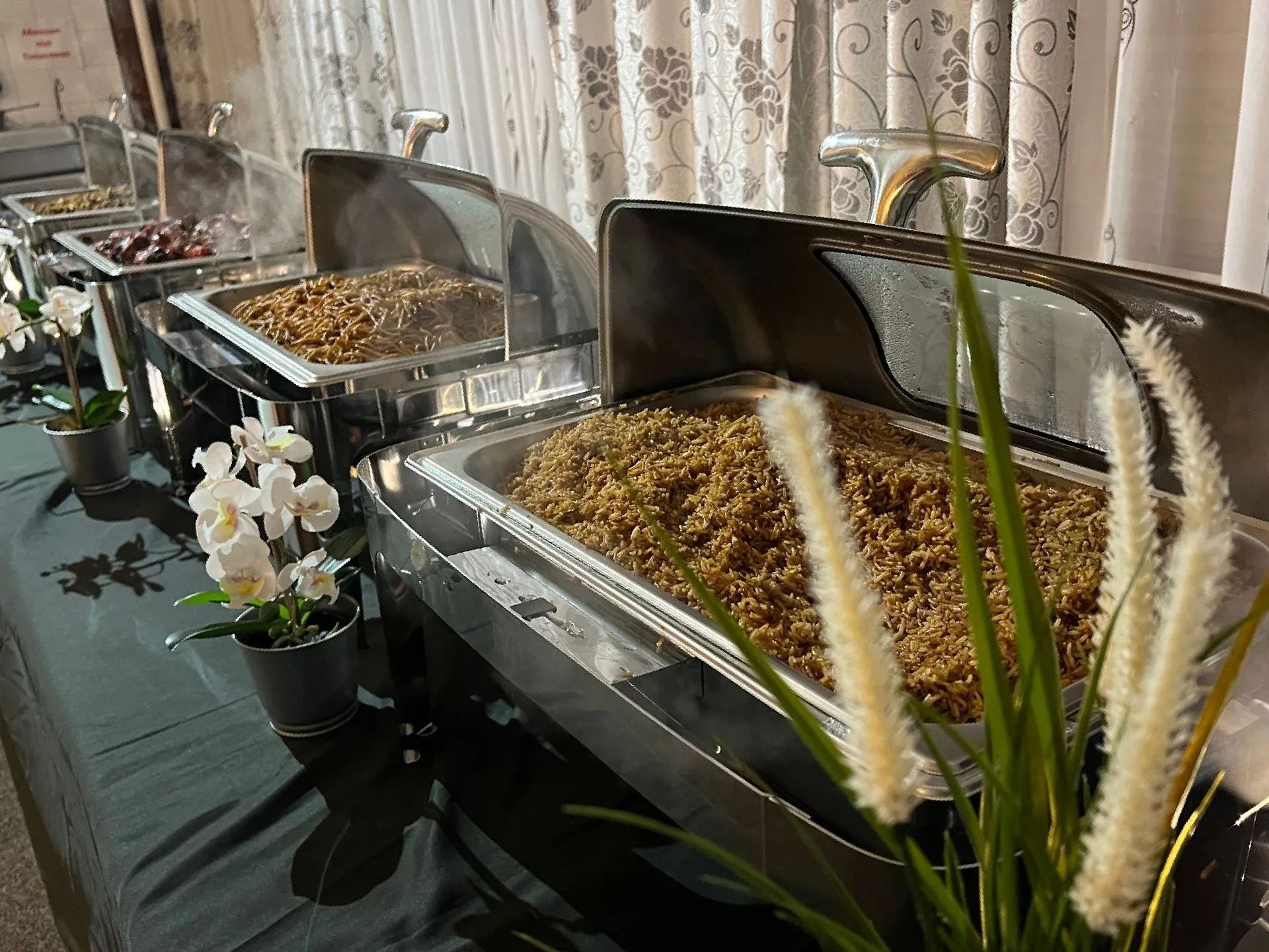 Een buffettafel met een verscheidenheid aan etenswaren en bloemen erop.