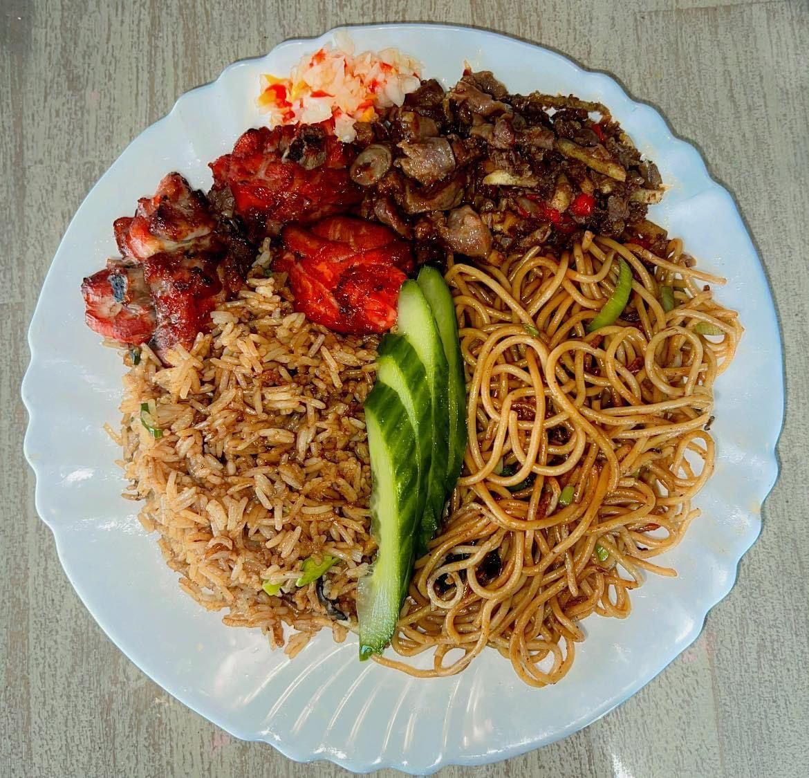 Een wit bord met daarop rijstnoedels en vlees