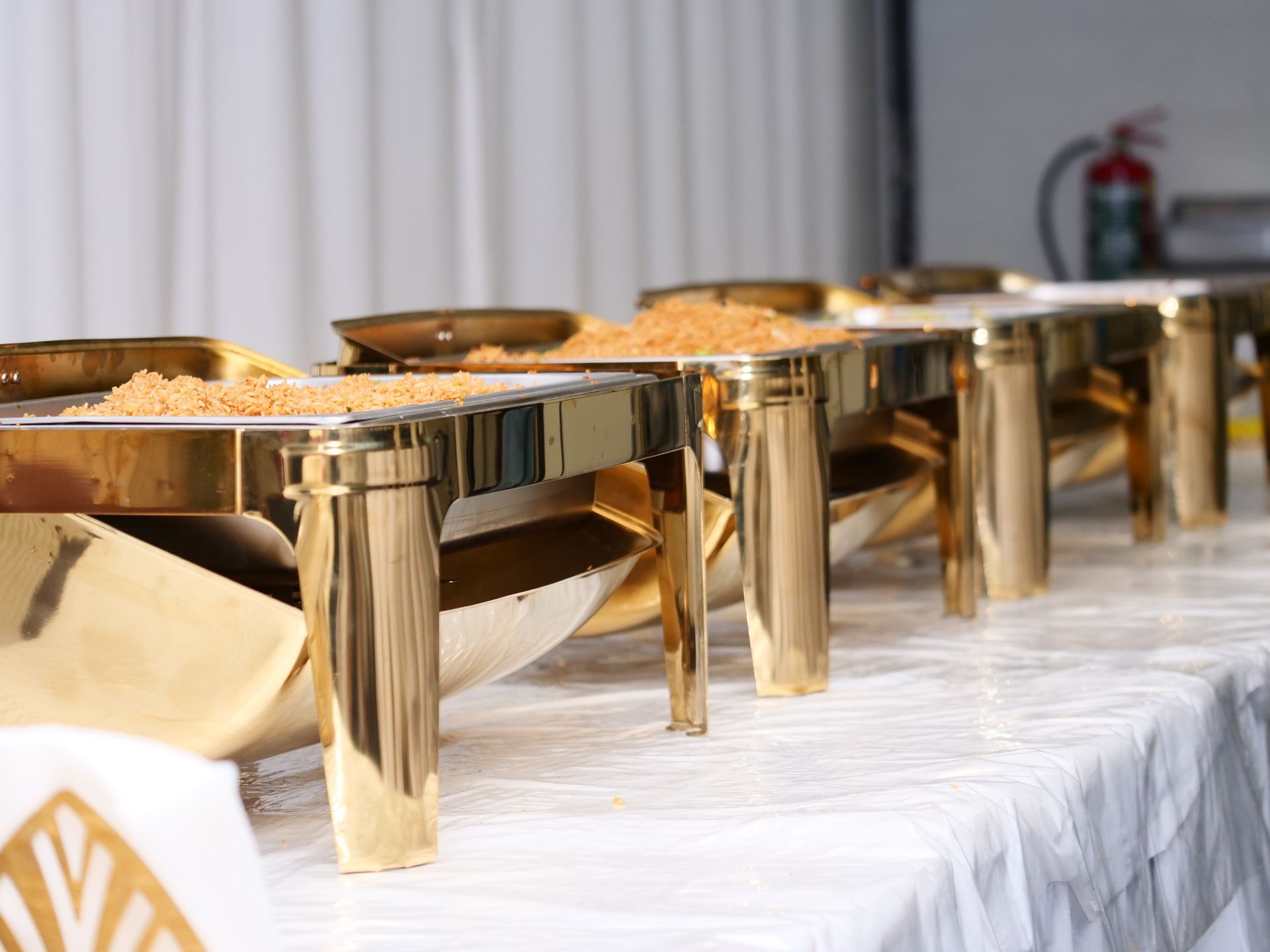 Een rij gouden dienbladen gevuld met eten op een tafel