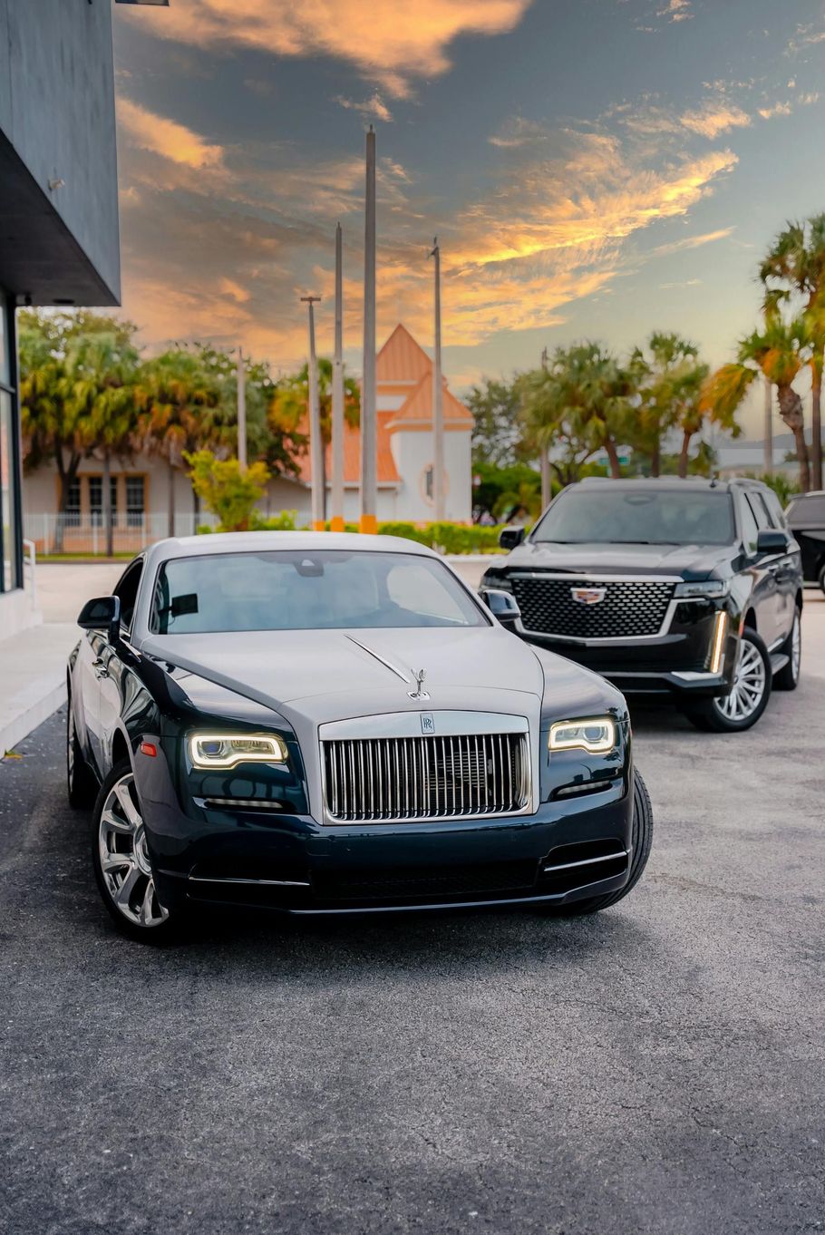 Two luxury cars are parked next to each other in a parking lot.