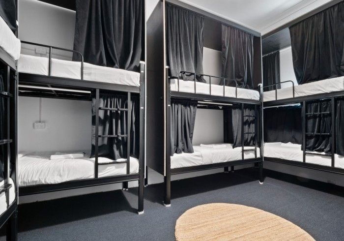 A room filled with bunk beds and a round table.
