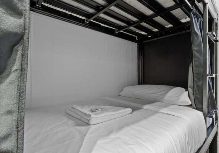A bunk bed with white sheets and pillows in a room.