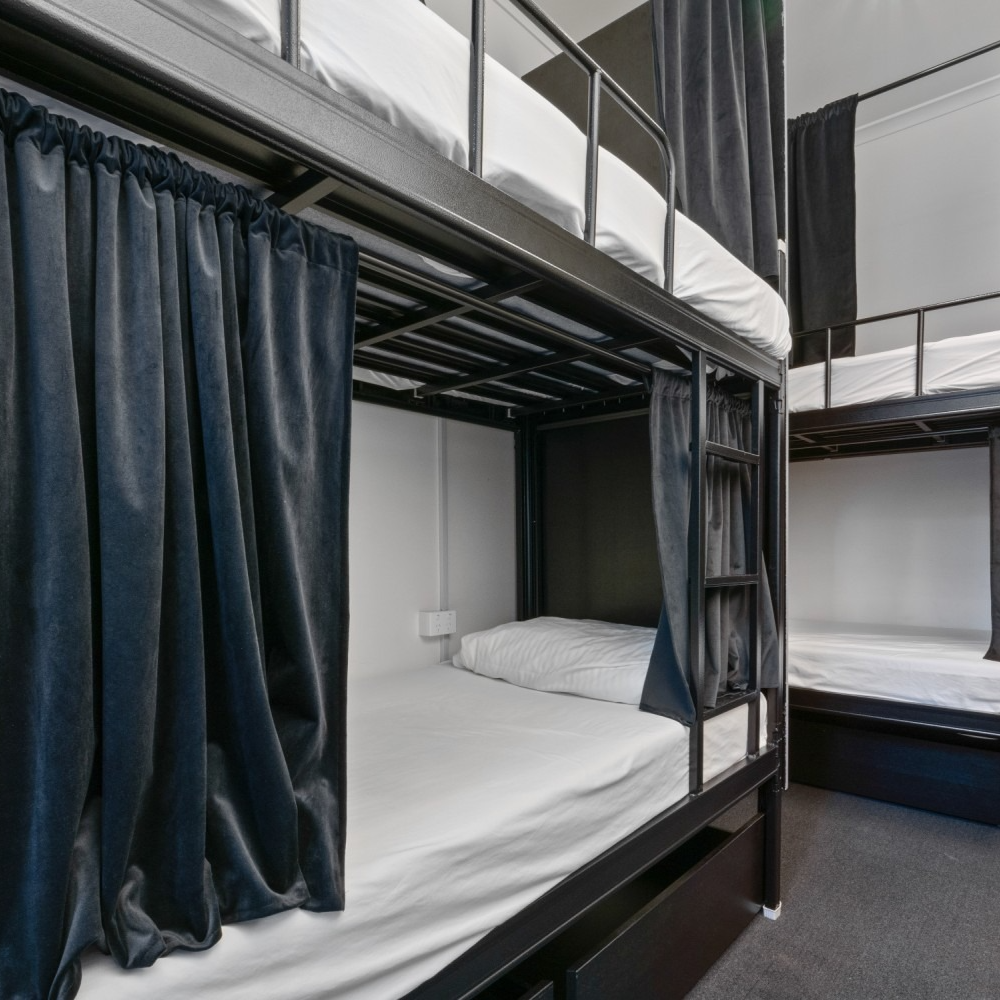 A room with bunk beds and curtains between them