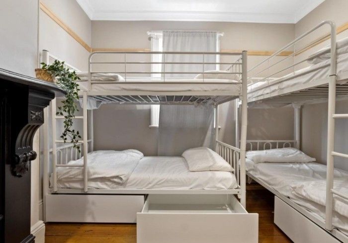 A room with four bunk beds and a fireplace.