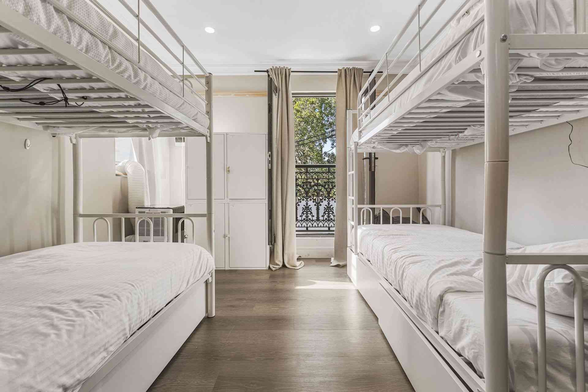A room with four bunk beds and a balcony.