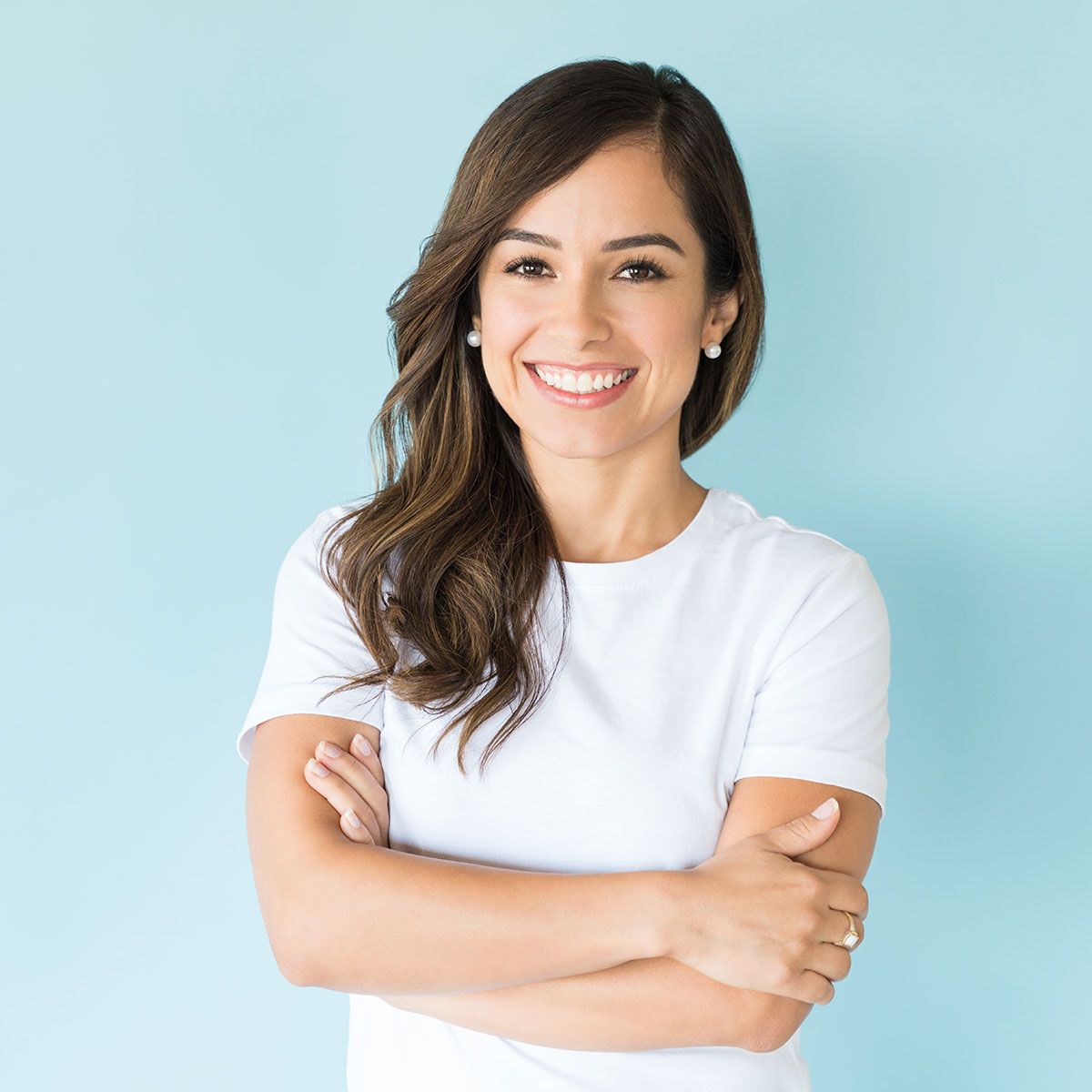 Confident woman with arms crossed in a studio